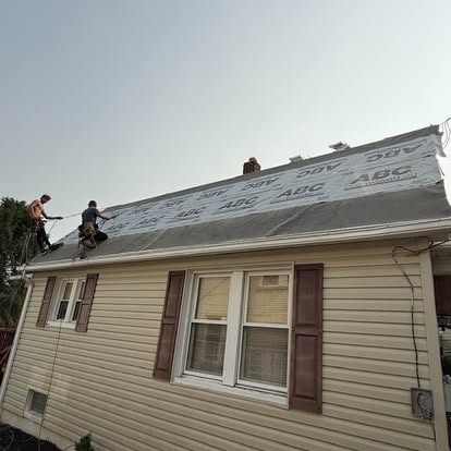 Roofers installing synthetic underlayment on a storm-damaged home in York County, Pennsylvania