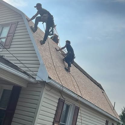 Thompson Home Improvements roofing crew harnessed on a steep roof installing architectural shingles in York County, Pennsylvania